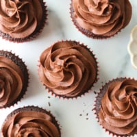 vegan ganache piped over chocolate cupcakes from overhead angle.