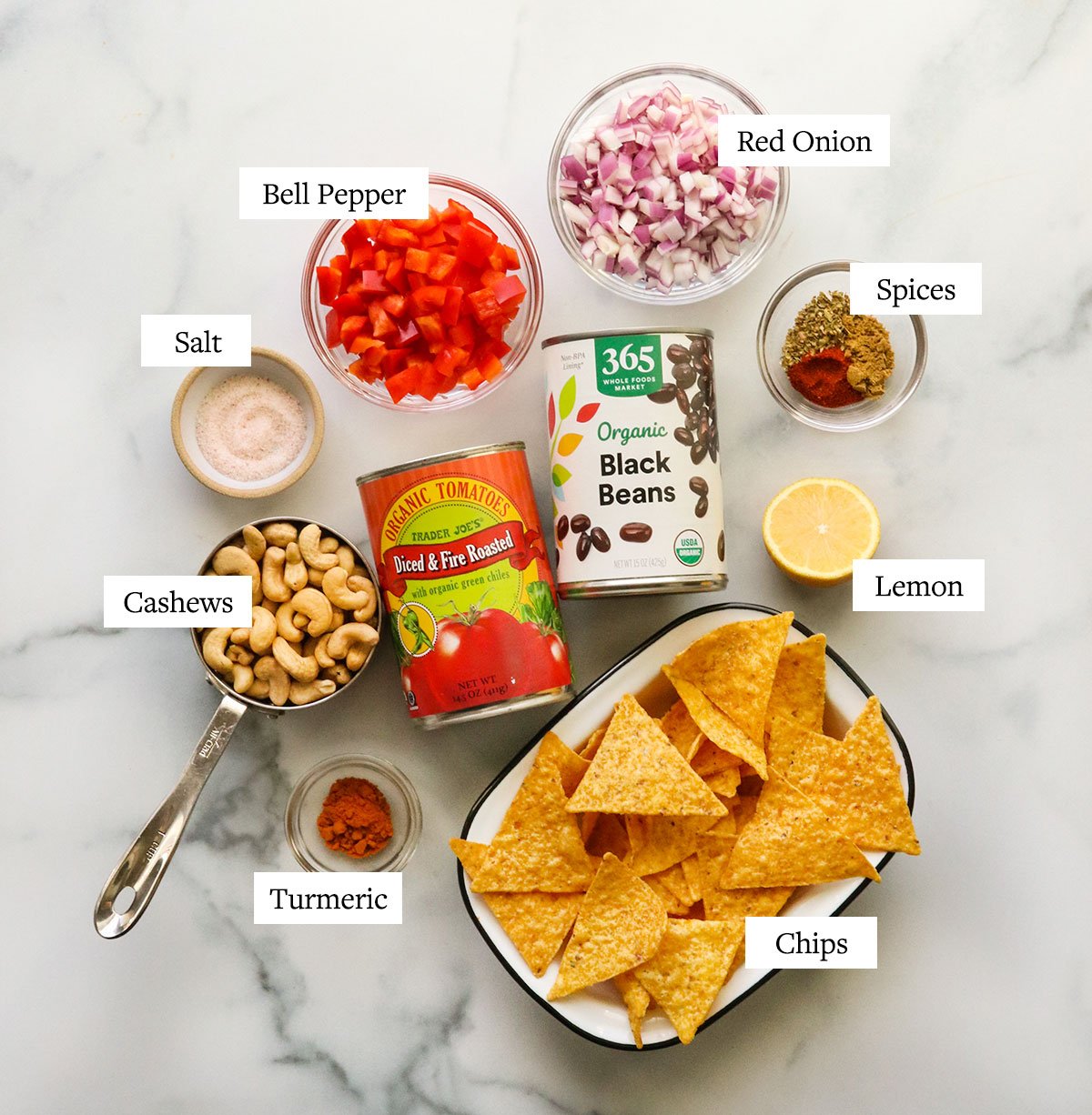vegan nacho ingredients labeled on a marble surface.
