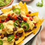 close up of vegan nachos topped with queso and jalapenos.