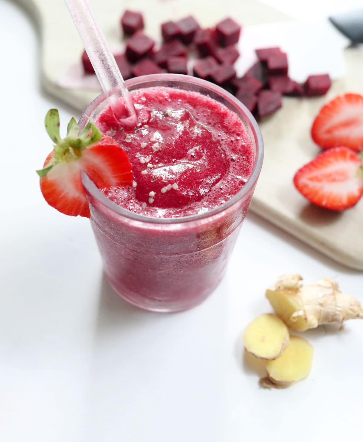 beet smoothie in a glass with straw