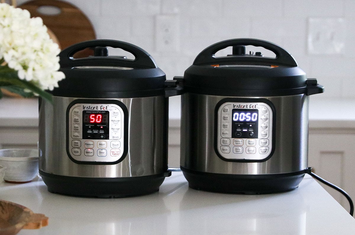 two instant pots side by side cooking beans for 50 minutes.