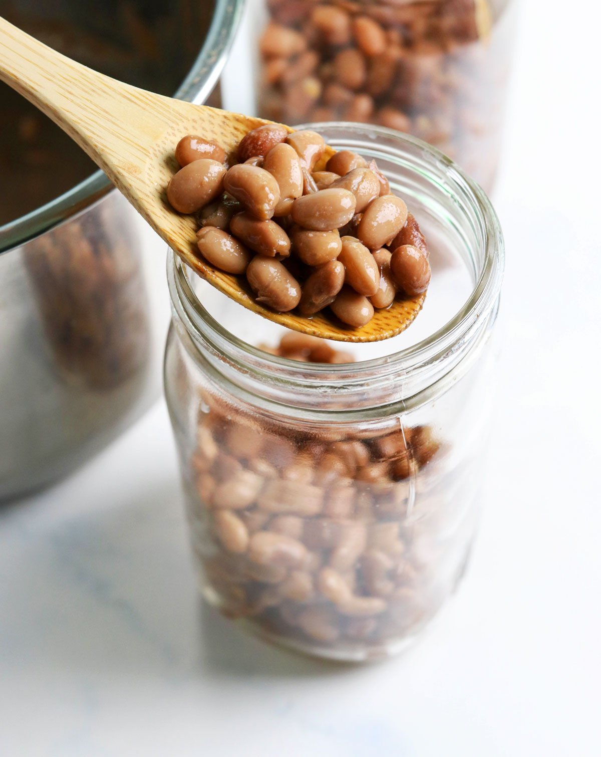 Pinto beans spooned into a glass jar