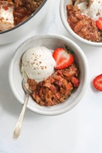 strawberry rhubarb crisp in a bowl with ice cream