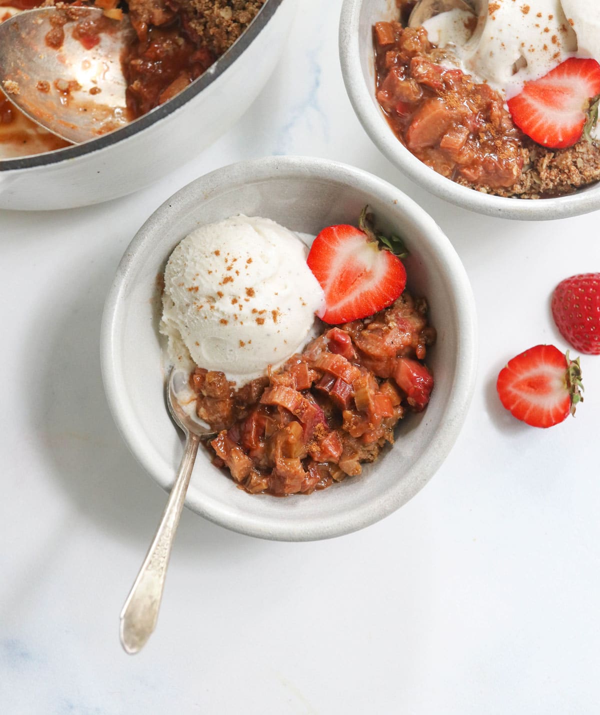 strawberry rhubarb crisp in a bowl with ice cream