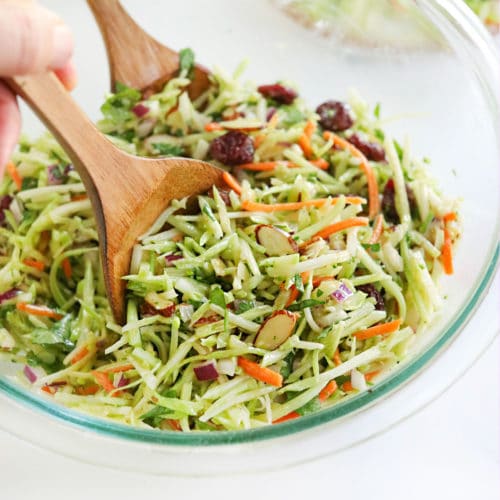 broccoli slaw tossed with wooden tongs
