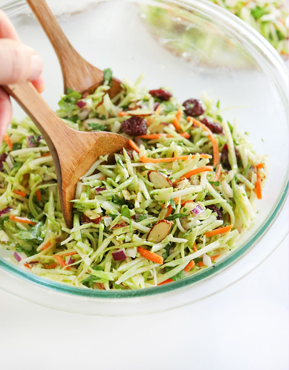 broccoli slaw tossed with wooden tongs