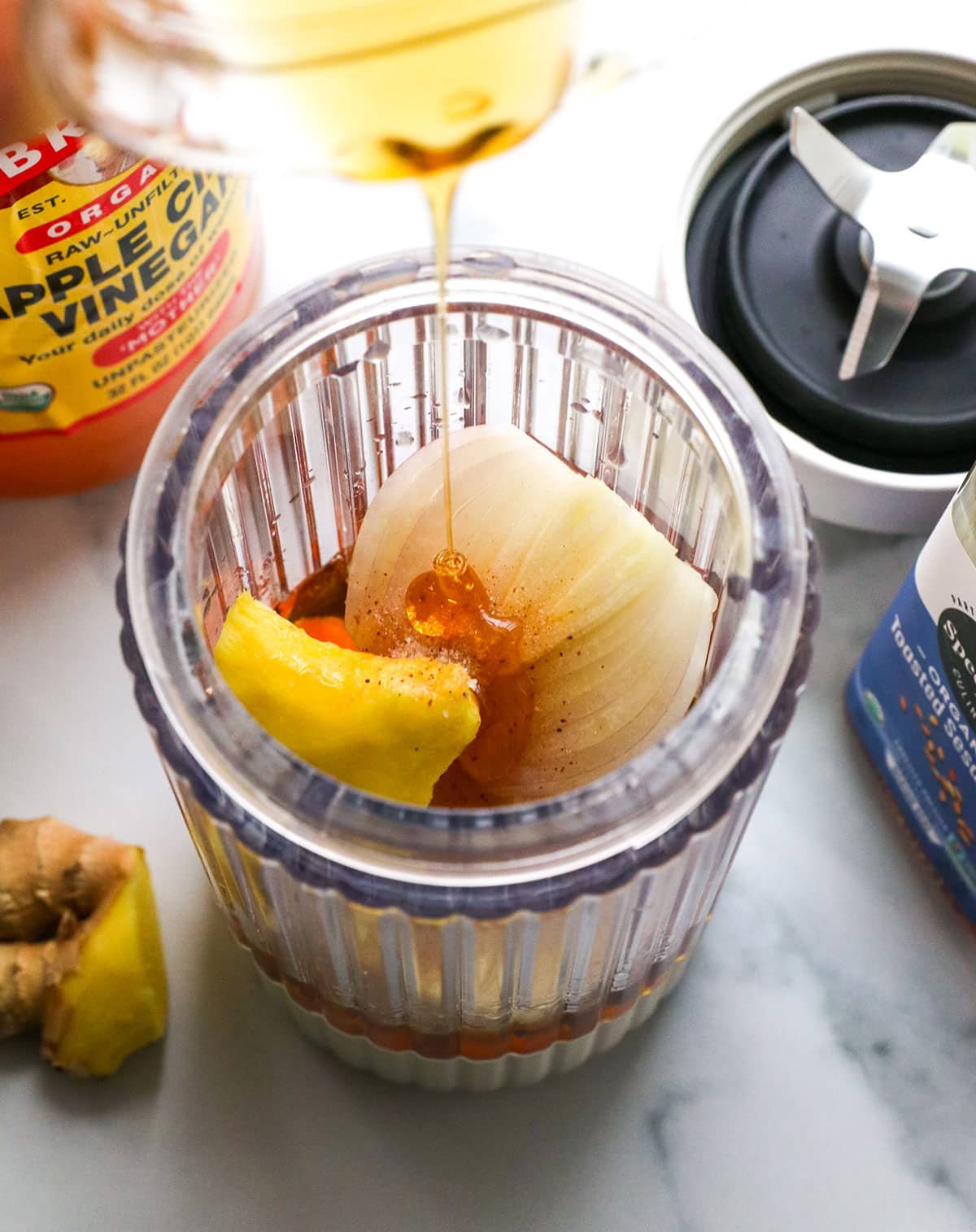 honey added to a small blender with ginger and shallot.