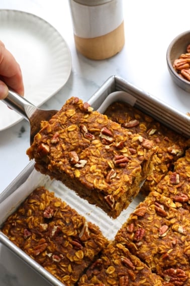 slice of pumpkin baked oatmeal lifted from a square pan.