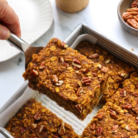 slice of pumpkin baked oatmeal lifted from a square pan.