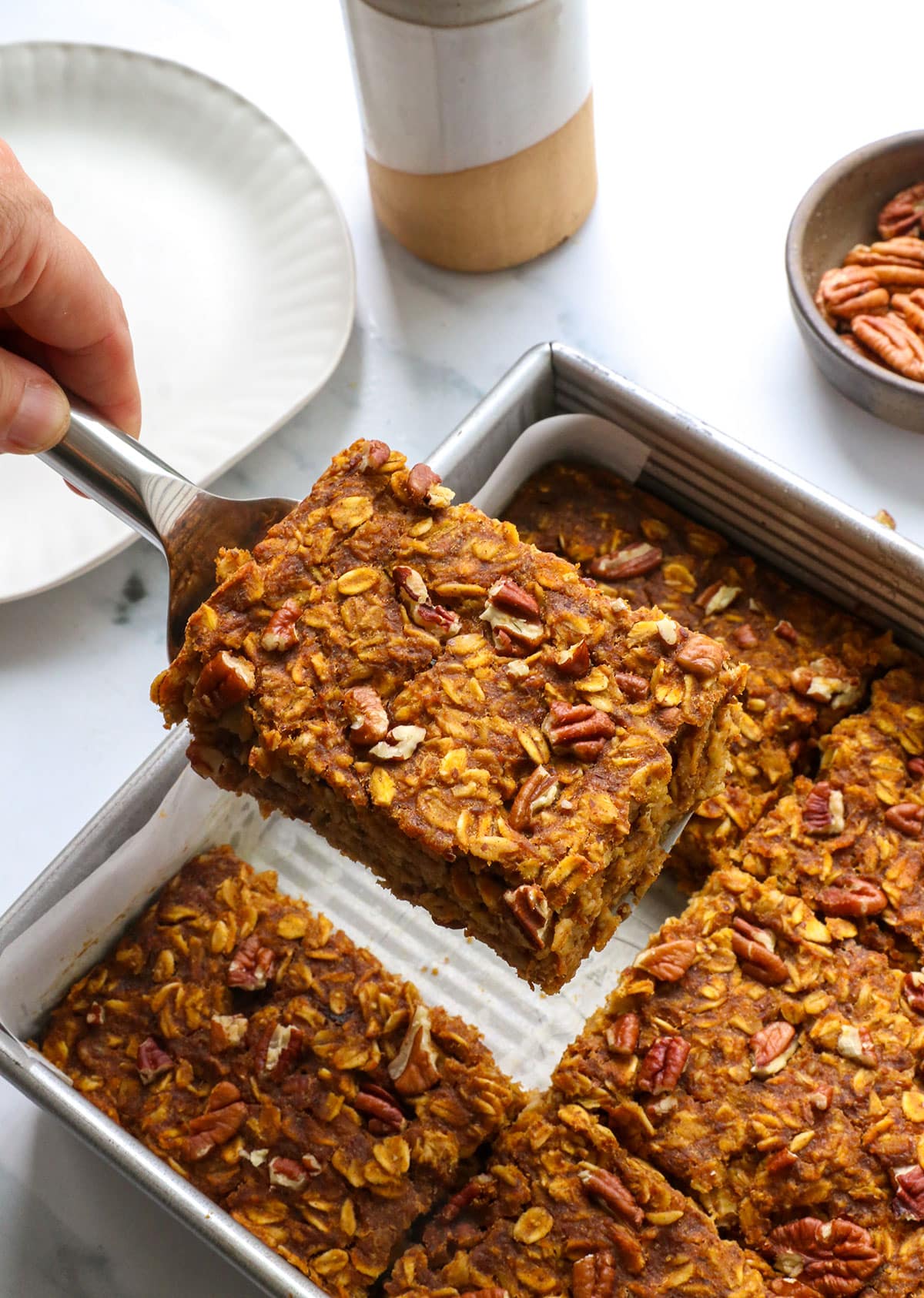 slice of pumpkin baked oatmeal lifted from a square pan.