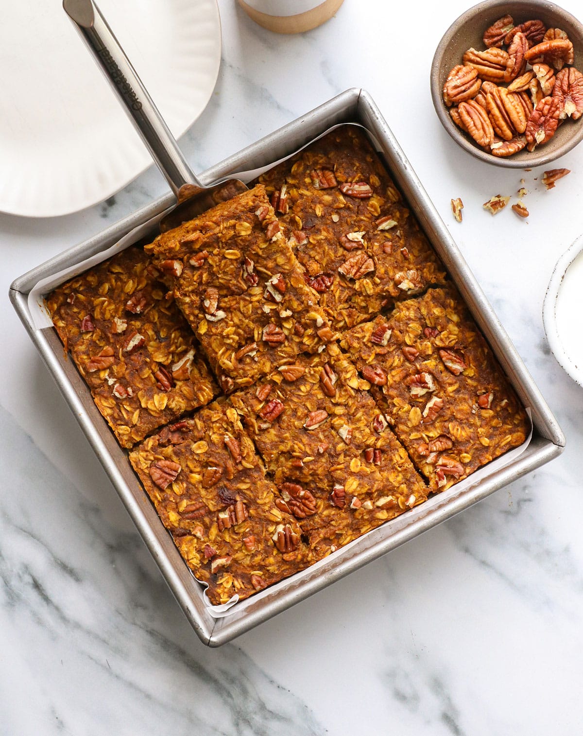 pumpkin baked oatmeal in a pan sliced into squares.