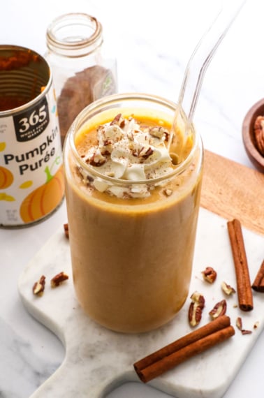 pumpkin smoothie topped with whipped cream in a glass.