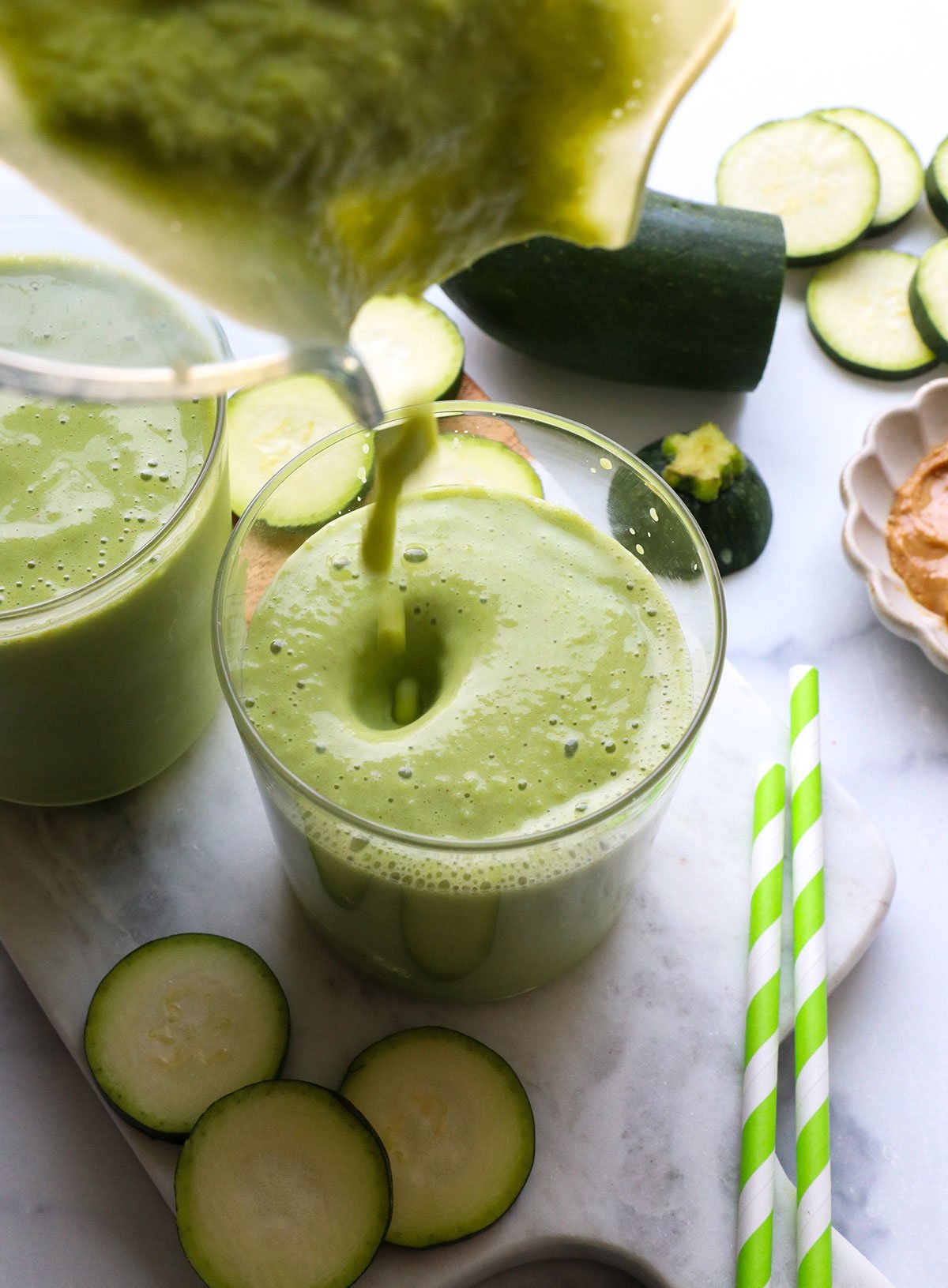zucchini smoothie poured into two glasses.