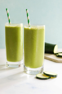 zucchini smoothie in two glasses with straws