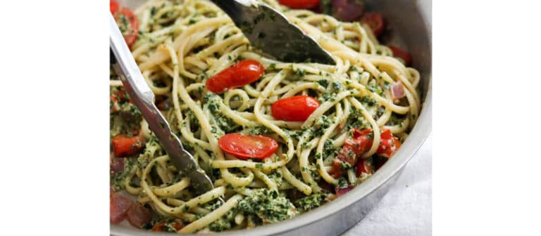 pasta and pesto tossed together in pan