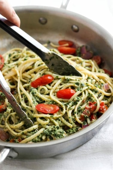 kale pesto tossed with noodles in pan