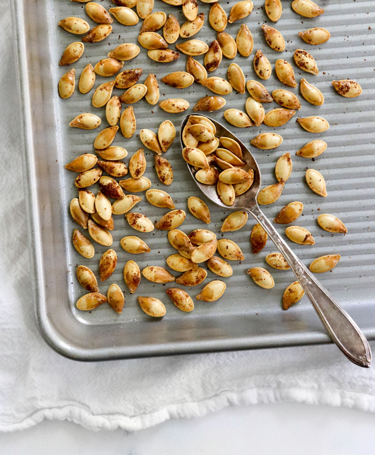 golden roasted pumpkin seeds on baking sheet