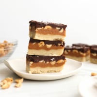 vegan snickers bars stacked on white plate.