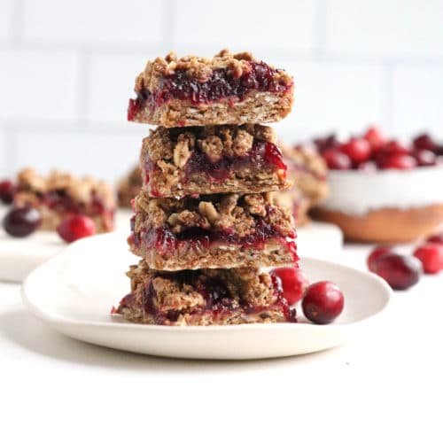 cranberry bars stacked on white plate