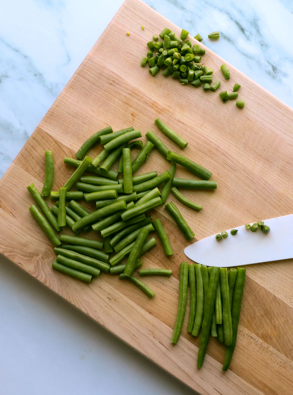 green beans cut into small pieces on a cutting board.  - 4