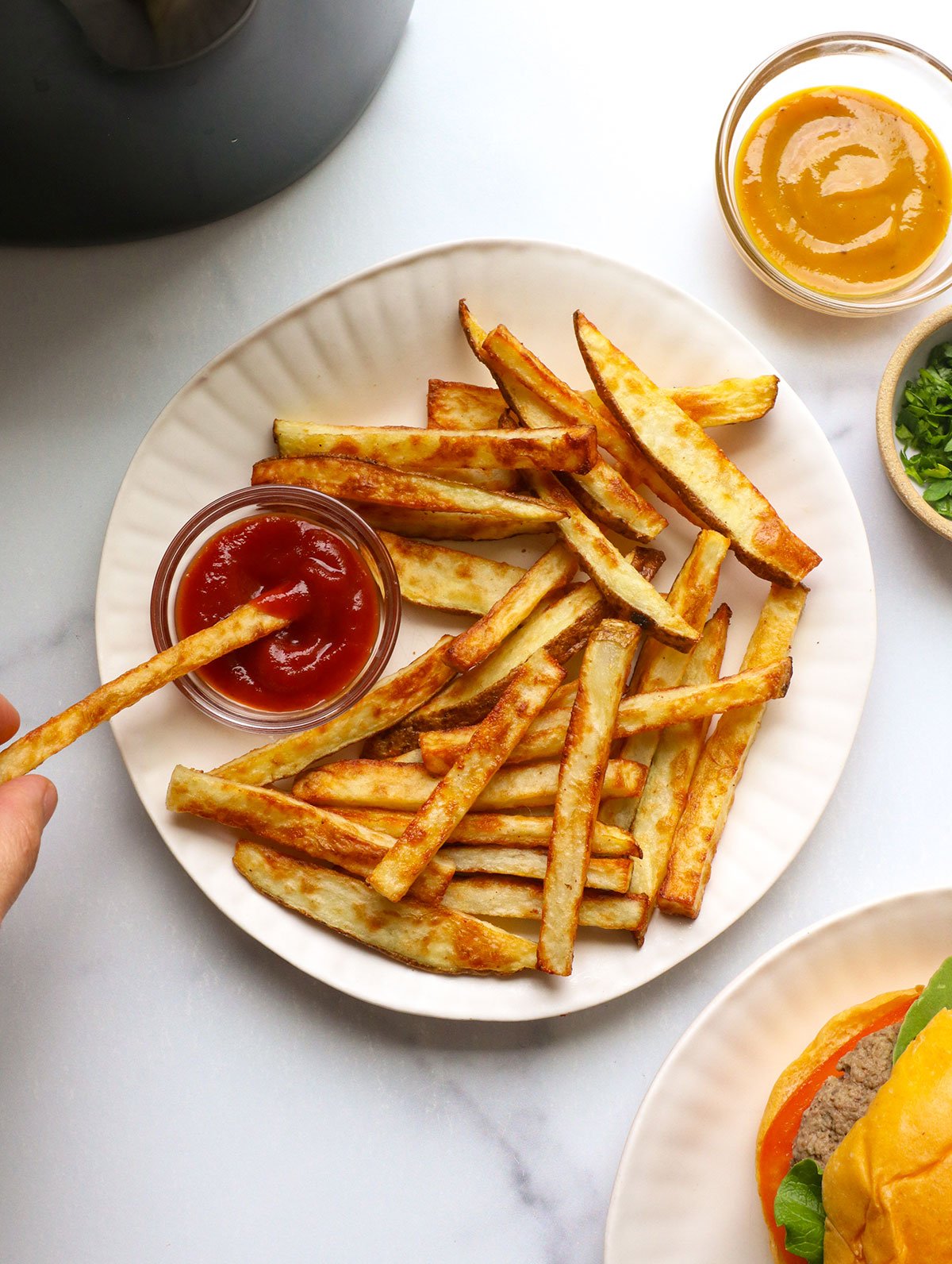 French fries dipped in tomato sauce on a white plate.