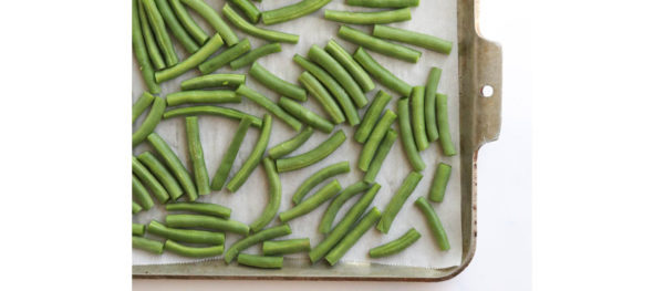 fresh green beans arranged on pan