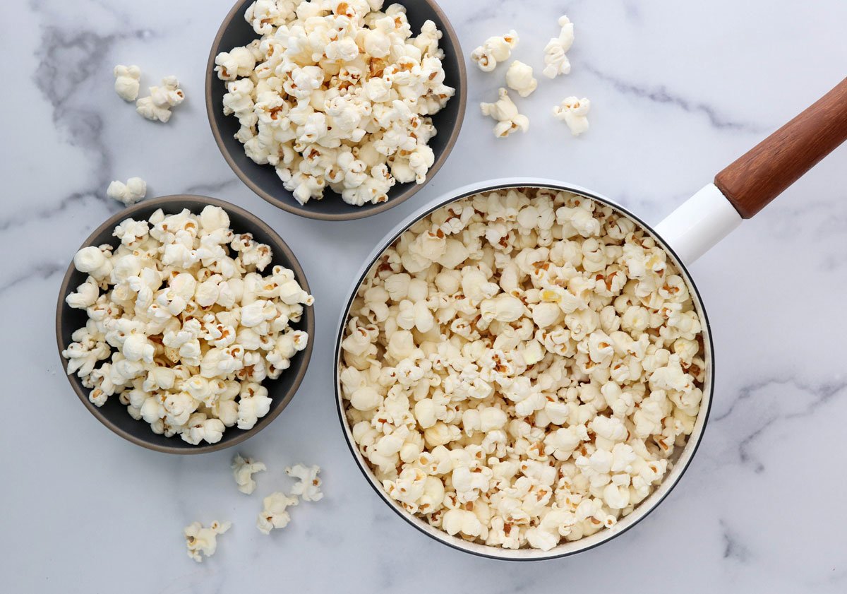 popcorn in pan and 2 bowls