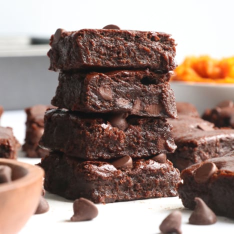 sweet potato brownies stacked on parchment paper.