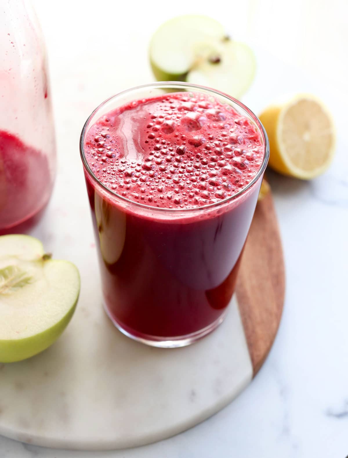 Fresh detox carrot juice in glass bottles on a gray stone