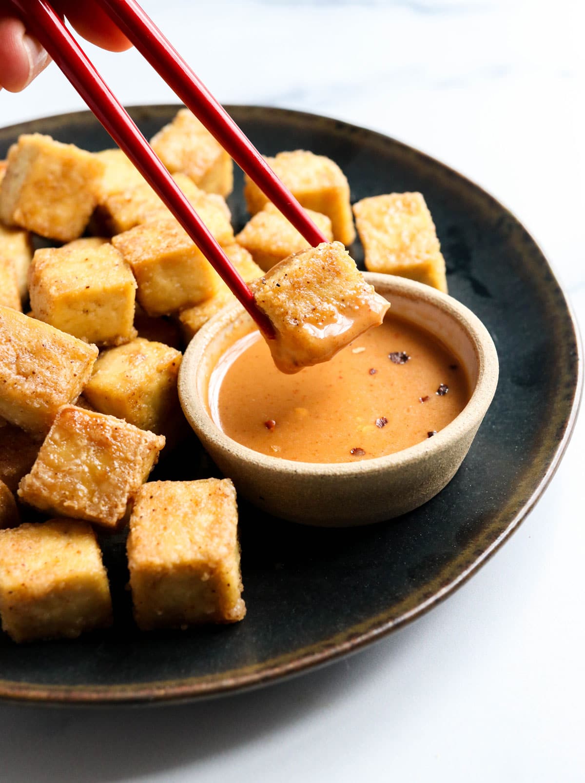 baked tofu dipped in sauce