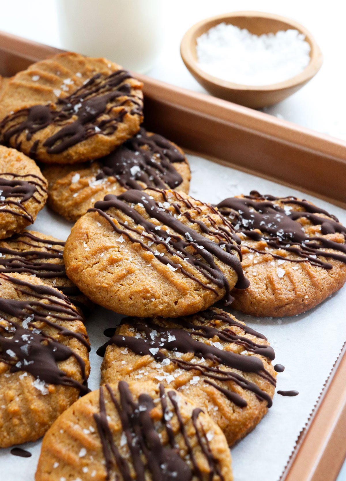 peanut butter cookies drizzled with dark chocolate on baking sheet