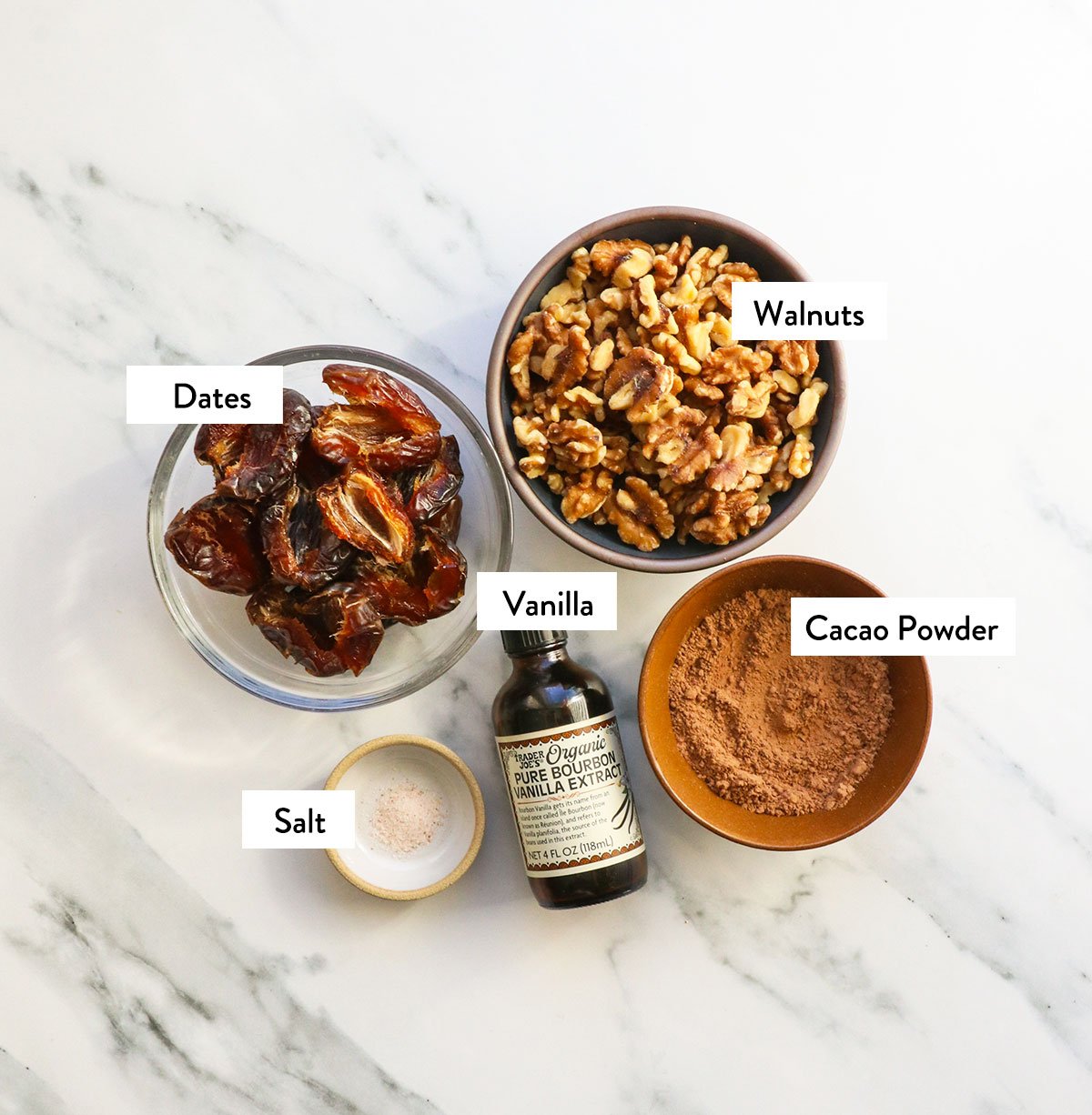 bowl of dates, walnuts, cacao powder, salt, and vanilla extract labeled. 