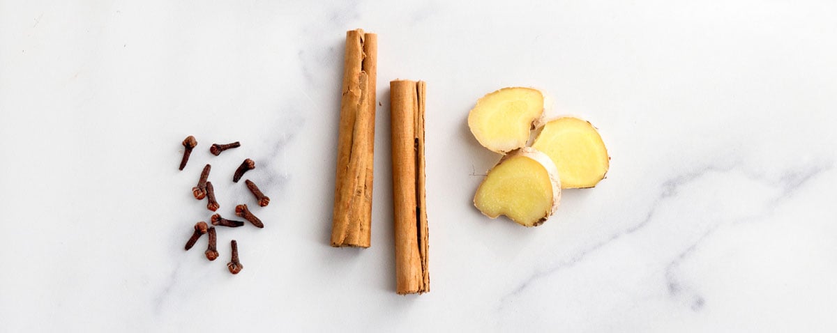 cloves cinnamon and ginger on marble surface