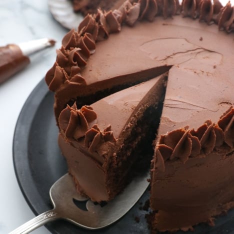chocolate almond flour cake sliced with frosting and ready to serve.