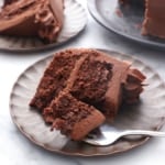 slice of chocolate almond flour cake on a dark plate with a fork.