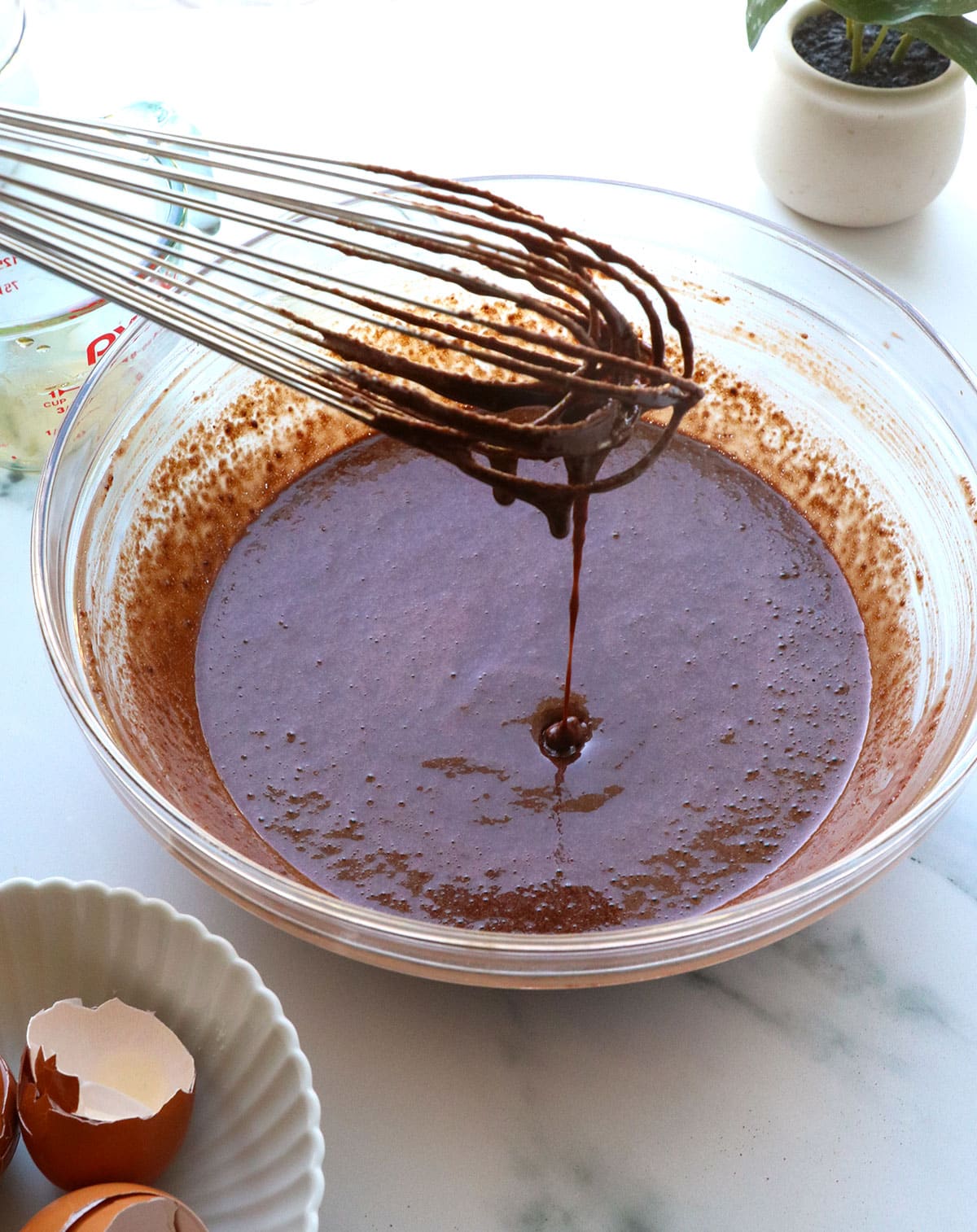 chocolate cake mixture dripping from the whisk into the bowl.
