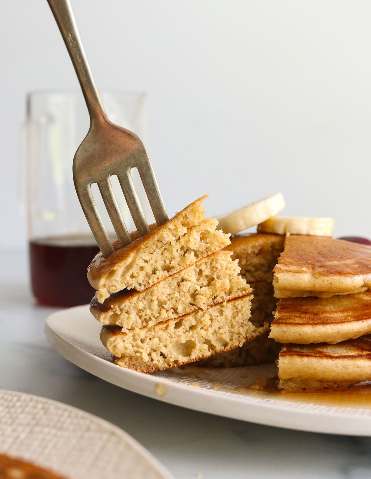 forkful of oat pancakes lifted from a stack.