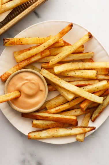 homemade fries served on a white plate with special sauce.