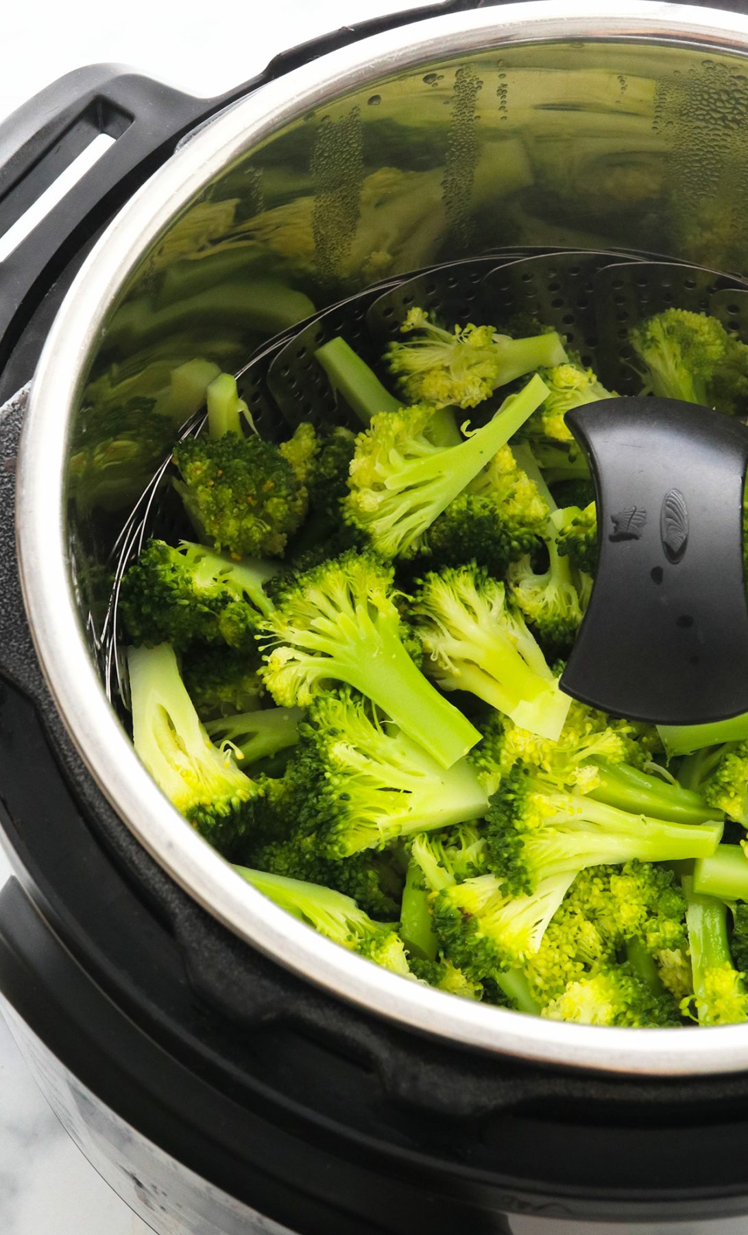 Cooked broccoli in a steamer basket in the Instant Pot.