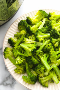 Instant Pot steamed broccoli served on a white plate.