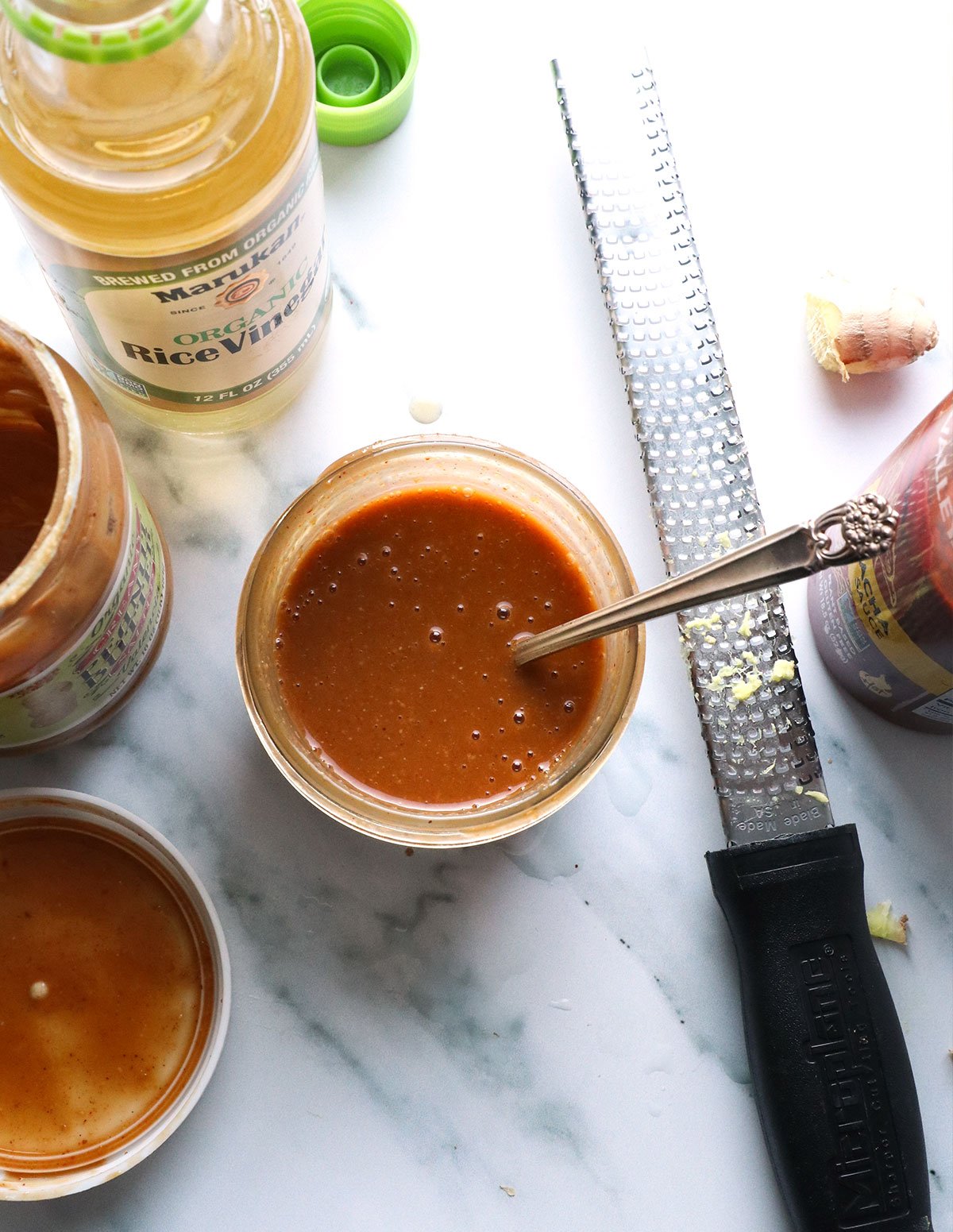 peanut dressing mixed smoothly in a jar with the lid nearby.