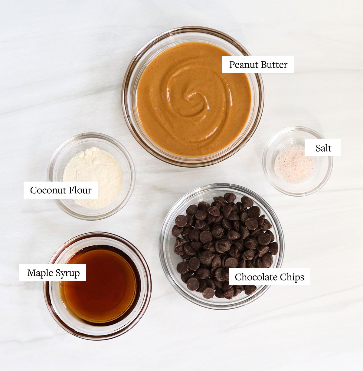 peanut butter egg ingredients labeled in glass bowls.