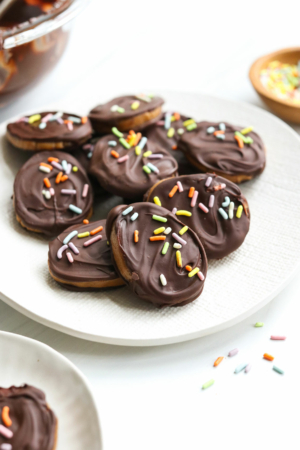 chocolate covered peanut butter eggs arranged on white plate with sprinkles.