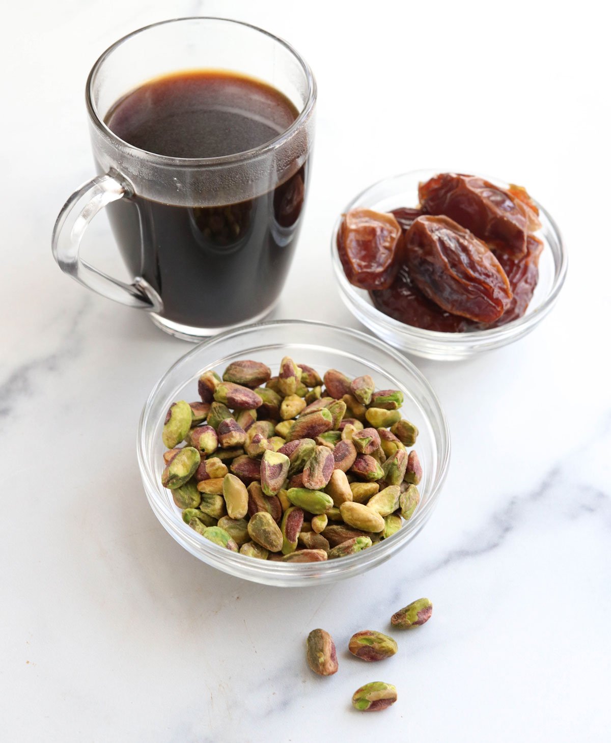 coffee pistachios and dates on marble surface