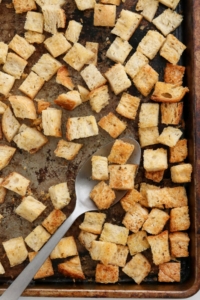 baked croutons on a pan with a spoon