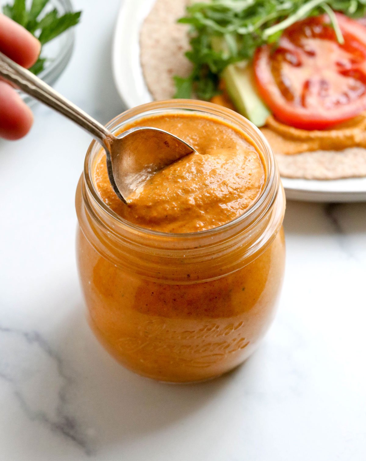 spoon in a jar of romesco sauce