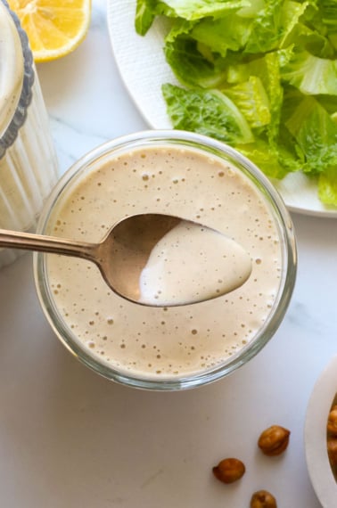 vegan caesar dressing lifted on a spoon.