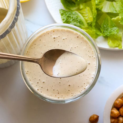 vegan caesar dressing lifted on a spoon.