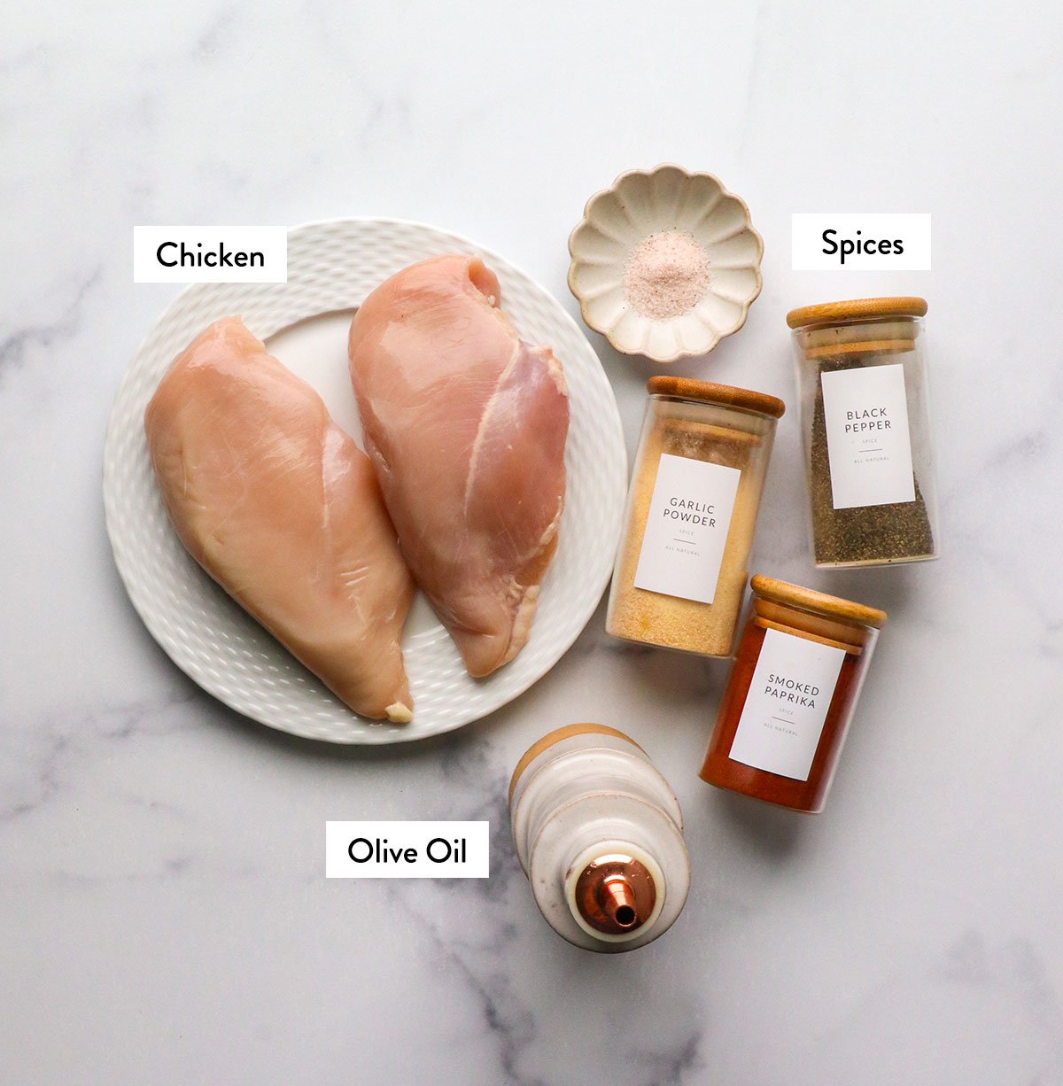 Chicken breast on a plate marked with spices and olive oil.