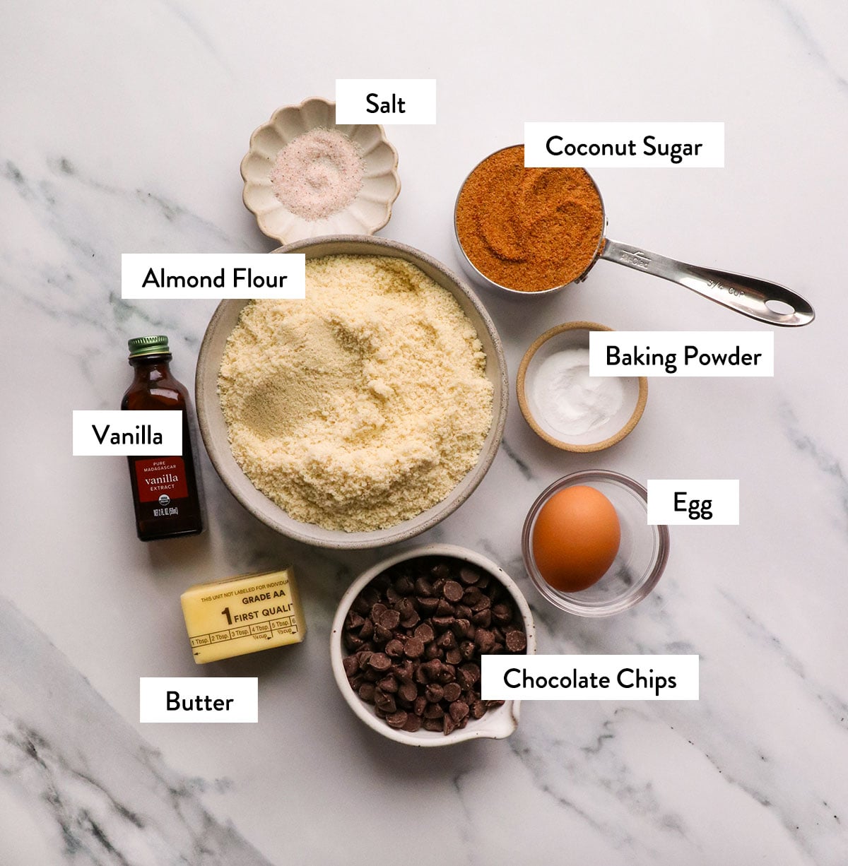 almond flour, coconut sugar, chocolate chips, and egg labeled in bowls.